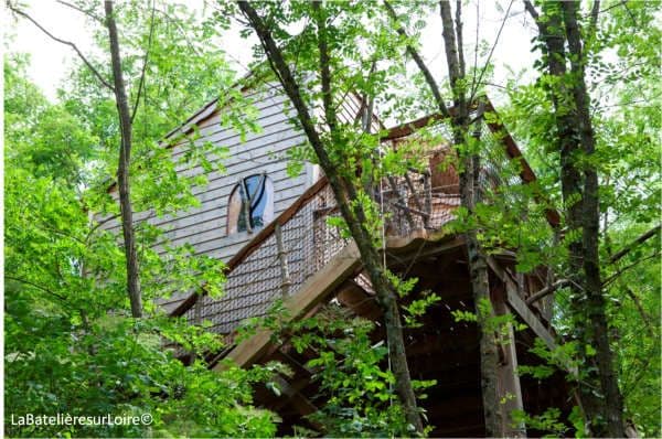  hébergement insolite touraine-Cabane en bois dissimulée derrière les branches et les feuilles de l'arbre sur lequel elle est installée