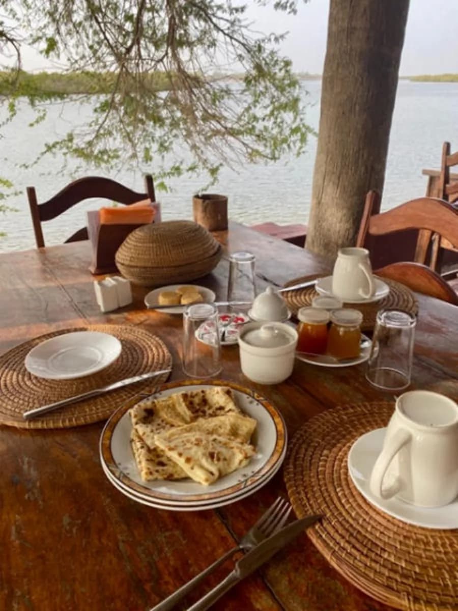 ecolodge sine saloum - Repas servi sur la terrasse couverte avec vue sur le fleuve