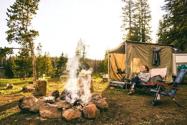 Campement avec une tente et un feu de camp