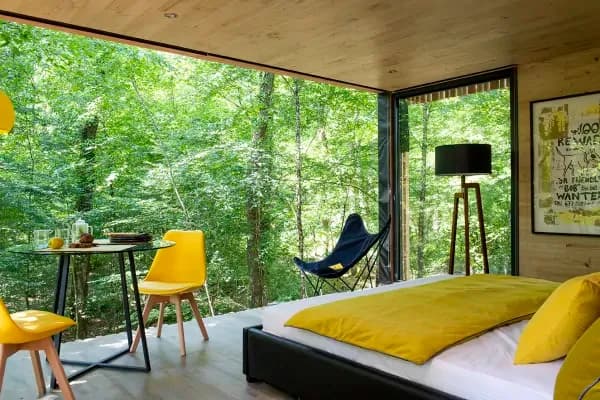 lit double avec baie vitrée sur la forêt 