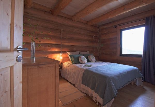 Photo d'une chambre avec un lit double au centre recouvert d'une couverture bleue