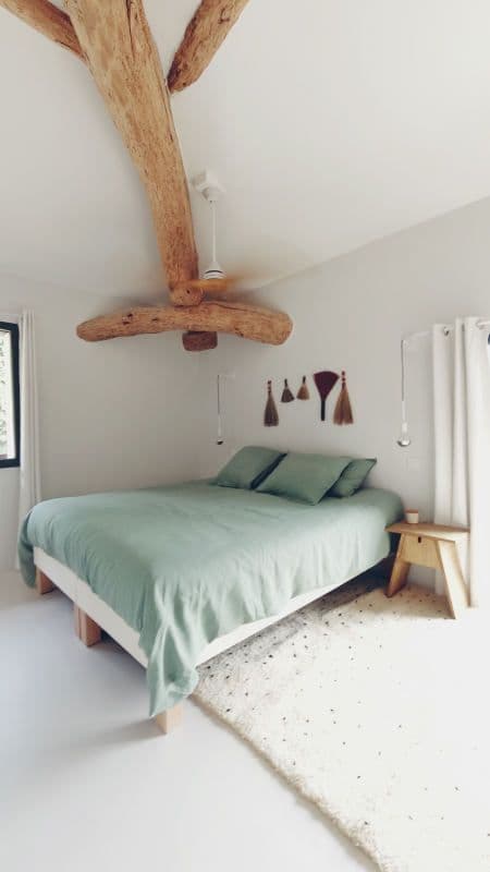 Chambre minimaliste avec poutre apparente et couleur principale vert clair