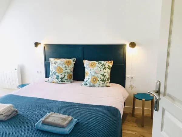 chambre avec lit double et sommier bleu et coussin à fleur